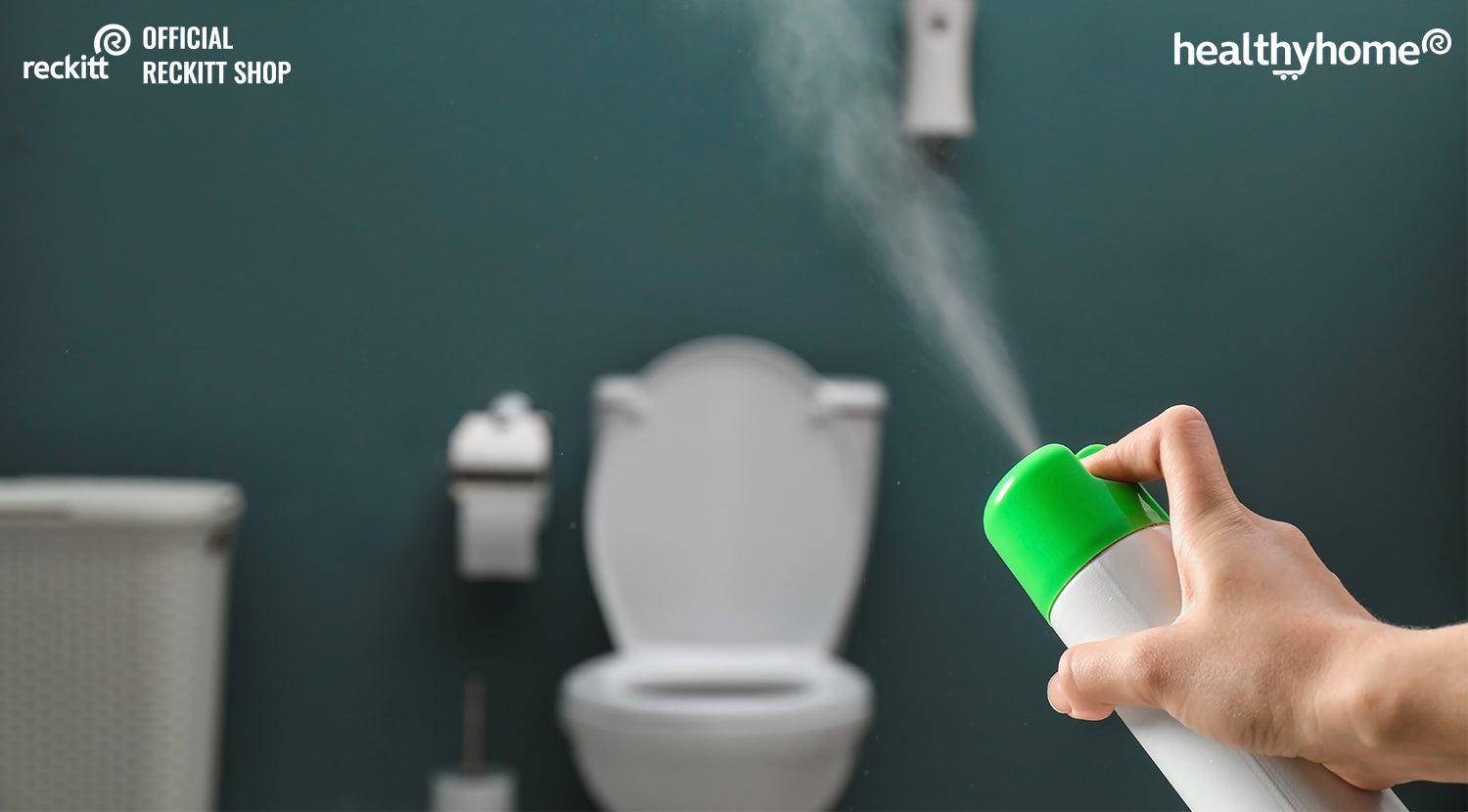 Spraying air freshener in bathroom 